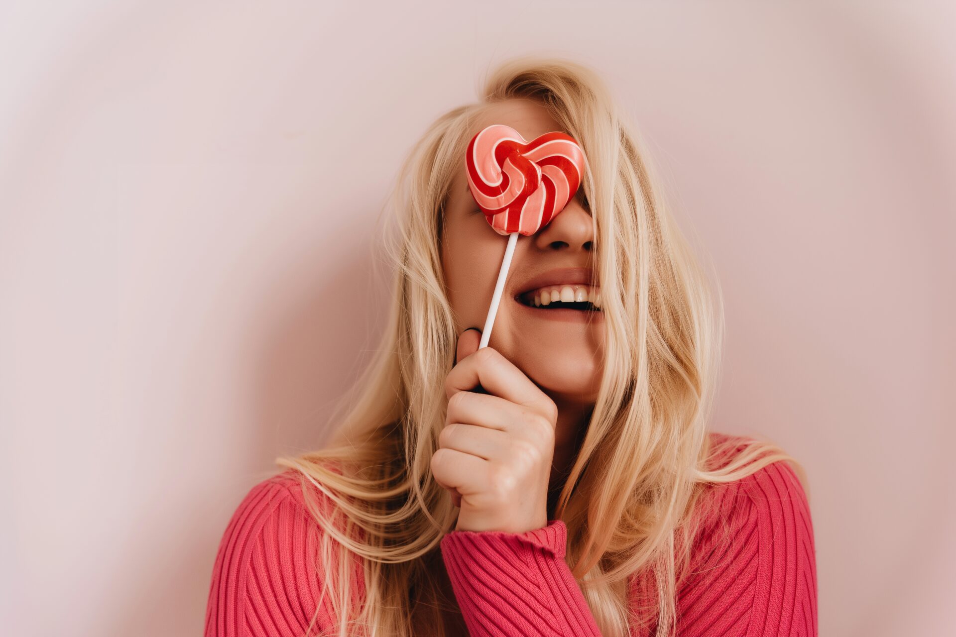 Frau hält Lollipop vor ihr Gesicht